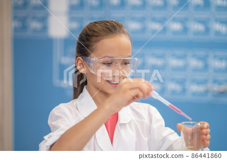 Smiling girl with pipette and test tube 86441860