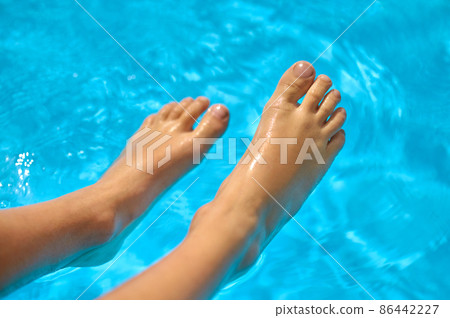 Childrens feet above water surface of pool Childrens feet above water surface of pool 86442227