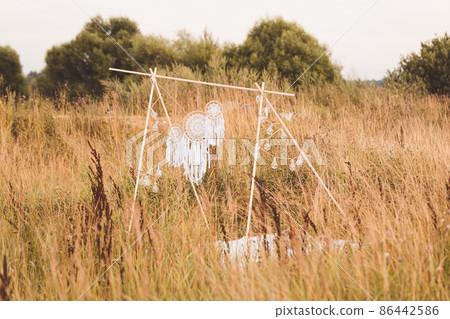 White cotton dreamcatcher at natural summer background, soft selective focus, toned White cotton dreamcatcher at natural summer background, soft selective focus, toned 86442586