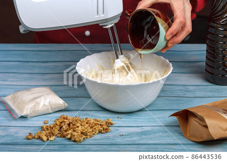 Caramel is poured into whipped egg whites 86443536