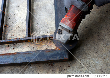 Close up, A man working with angle grinder. Iron gate repair 86443943
