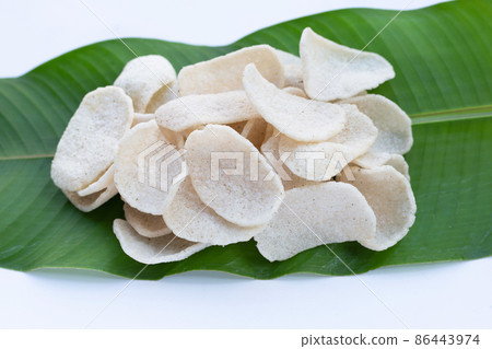 Prawn crackers on green leaf on white background. Shrimp crispy rice snack 86443974