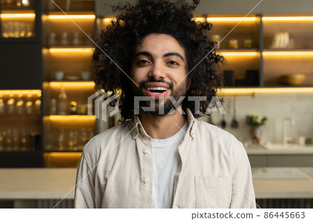 Cheerful Arabian man smiles looking in camera in kitchen 86445663