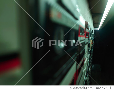 Close-up large collection audio cassettes in dark, gloomy, cinematically illuminated in low light. Great depth of field, bokeh, blur. Retro, magnetic tape, transparent case with signature paper 86447801
