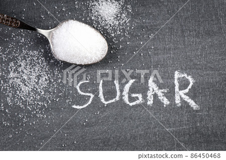 SUGAR. Chalk drawing. Teaspoon with white sugar on a blackboard 86450468