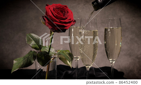 Sparkling wine and red roses in close-up 86452400