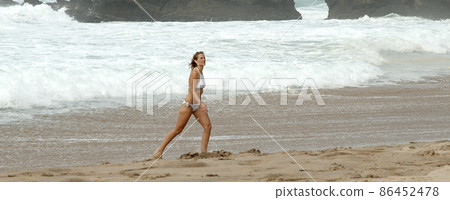 Young and sexy woman has fun on the sandy beach at the Atlantic ocean Young and sexy woman has fun on the sandy beach at the Atlantic ocean 86452478