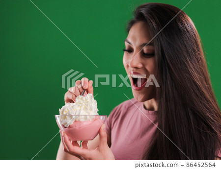 Young happy woman enjoys her bowl of ice cream Young happy woman enjoys her bowl of ice cream 86452564