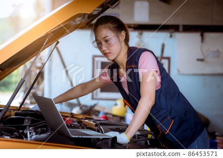 Woman car mechanic wearing glass and glove open car hood repairing check car problem system check detail for maintenance and fixed in car garage. Woman car mechanic wearing glass and glove open car hood repairing check car problem system check detail for maintenance and fixed in car garage. 86453571