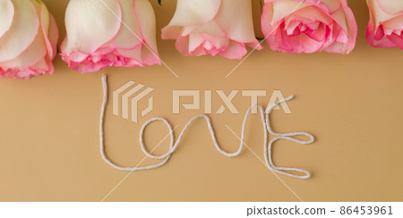 Delicate pink roses on beige background. Word LOVE made of rope. Minimal trendy composition. Romantic pastel pink rose flowers. Neutral earth tones. Greeting card for Valentines day Delicate pink roses on beige background. Word LOVE made of rope. Minimal trendy composition. Romantic pastel pink rose flowers. Neutral earth tones. Greeting card for Valentines day 86453961