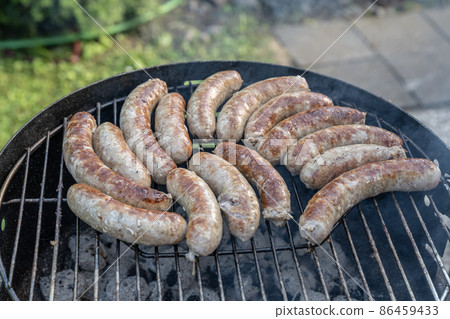 Barbecue grill bbq on coal charcoal grill with raw bratwurst sausages meat delicious summer meal 86459433