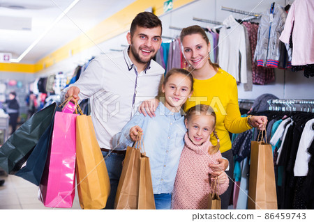 family of four with shopping bags 86459743