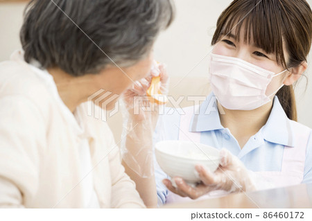 採取措施防止感染並餵粥的看護女性 採取措施防止感染並餵粥的看護女性 86460172