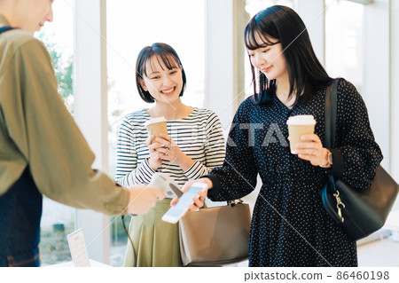 Two women who make a smartphone payment 86460198