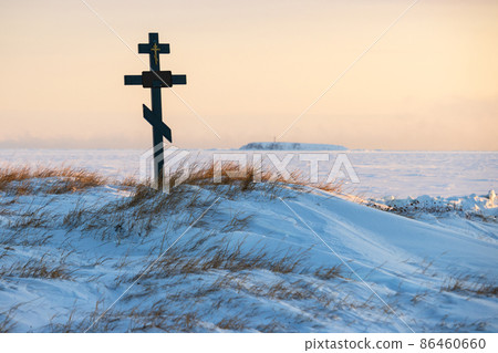 Orthodox cross in the snowy tundra on the coast of the frozen sea. Orthodox cross in the snowy tundra on the coast of the frozen sea. 86460660