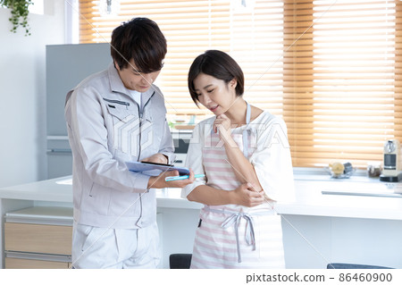 A man wearing work clothes with a housewife who consults on home remodeling 86460900