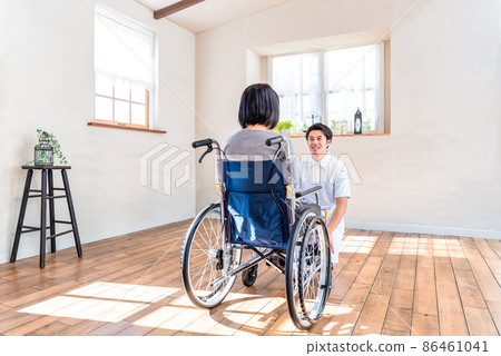 Rehabilitation Center Male caregiver checking the situation with female residents Rehabilitation Center Male caregiver checking the situation with female residents 86461041