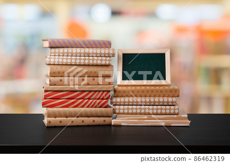 Stack of books on wooden table against blurred background Stack of books on wooden table against blurred background 86462319