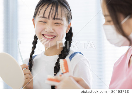 Girl receiving tooth brushing instruction in dentistry Girl receiving tooth brushing instruction in dentistry 86463718