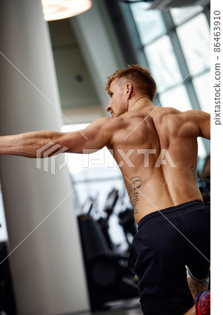 Rear view of Attractive young fit and toned sportswoman working out with battle ropes. Motion blur Rear view of Attractive young fit and toned sportswoman working out with battle ropes. Motion blur 86463910
