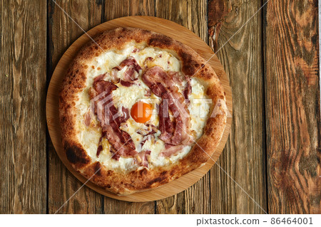 Carbonara pizza with bacon and egg on wooden background 86464001