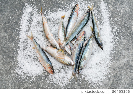 Whole raw organic mackerel fish with sea salt lying on a flat surface 86465366