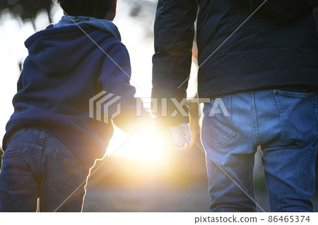 家庭背後的手在背光燈下手牽手 86465374