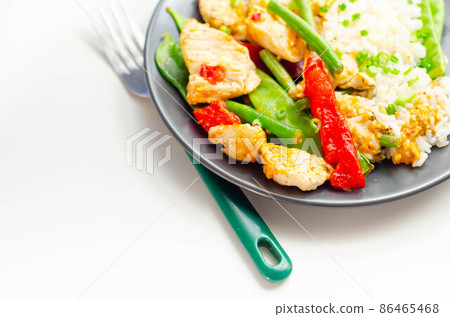 Chicken breast pieces in a Thai red curry sauce made with coconut cream, red chillies, lemongrass, lime leaf, with fragrant rice, red peppers, mange tout, and green beans 86465468