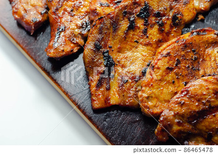 Fresh and juicy pork loin steaks, grilled meats on the wooden board Fresh and juicy pork loin steaks, grilled meats on the wooden board 86465478