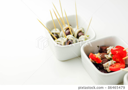 The traditional Spanish appetizers of olives, tomatoes and anchovies in a white ceramic bowls The traditional Spanish appetizers of olives, tomatoes and anchovies in a white ceramic bowls 86465479