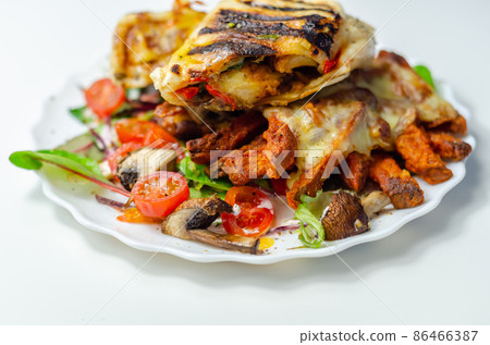 Grilled tortilla wrap with southern style chicken breast with sweet potato fries served on the mix salad Grilled tortilla wrap with southern style chicken breast with sweet potato fries served on the mix salad 86466387