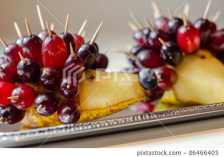 Fruit hedgehog, red grapes and juicy pear, creative way of serving fruit Fruit hedgehog, red grapes and juicy pear, creative way of serving fruit 86466405