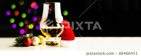 single malt  whisky in tasting glass on christmas background, colorful bokeh 86466451