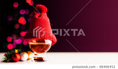 single malt  whisky in tasting glass on christmas background, colorful bokeh 86466452