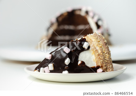 Chocolate sponge cake, coated and filled with marshmallow flavour frosting, chocolate flavour frosting, decorated in the digestive crumb with chocolate sauce and marshmallows 86466554