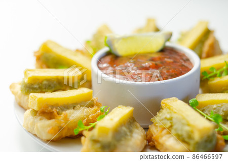 Skinless and boneless battered Alaska Pollock fillet pieces, topped with mushy peas and fried potato Skinless and boneless battered Alaska Pollock fillet pieces, topped with mushy peas and fried potato 86466597