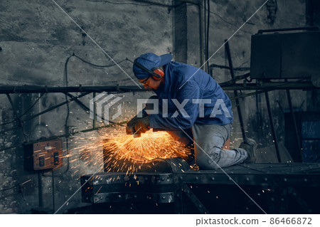 Qualified welder working with metal frame indoors 86466872