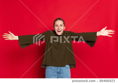 Excited young beautiful girl, student with short hair in dark sweater isolated on red background. Concept of emotions, studying, ad, gender x Excited young beautiful girl, student with short hair in dark sweater isolated on red background. Concept of emotions, studying, ad, gender x 86466925