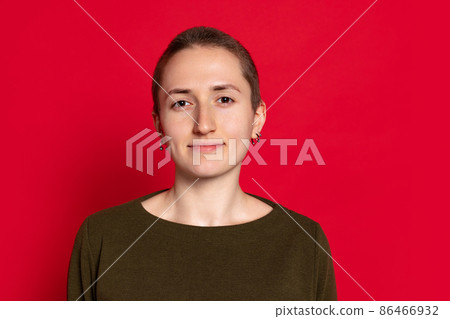 Portrait of young smiling woman, student with short hair in dark sweater isolated on red background. Concept of emotions, studying, ad Portrait of young smiling woman, student with short hair in dark sweater isolated on red background. Concept of emotions, studying, ad 86466932