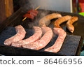 Fresh delicious grilled and fried bavarian sausages with sticks. Street food at local market of traditional festival, street food market vendor 86466956