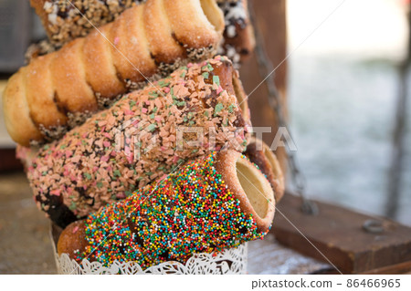 Fresh cooked traditional Czech trdlo or trdelnik, at street food market stall. National street food in Czech Republic and Hungary. Hungarian kurtoskalacs Fresh cooked traditional Czech trdlo or trdelnik, at street food market stall. National street food in Czech Republic and Hungary. Hungarian kurtoskalacs 86466965