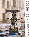 Vertical image of vintage cooper candlestick in art nouveau style on flea market or thrift store sale. Collecting of antiques and different vintage things. Collectibles memorabilia and garage sale 86466966