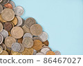 Variety of old coins on light blue background with copy space. Various vintage coins from worldwide as background. Financial growth and business concept. Numismatics and coin collecting 86467027