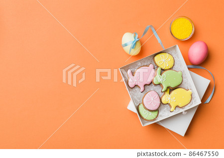 Colorful easter cookies in basket with Multi colors Easter eggs on colored background . Pastel color Easter eggs. holiday concept with copy space Colorful easter cookies in basket with Multi colors Easter eggs on colored background . Pastel color Easter eggs. holiday concept with copy space 86467550