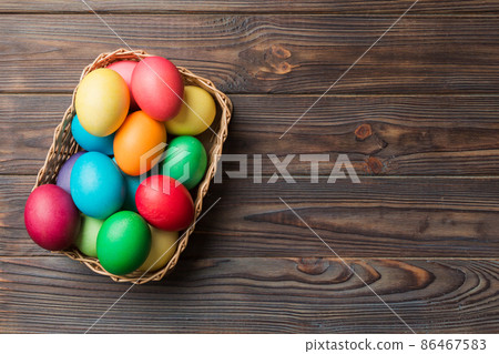 Multi colors Easter eggs in the woven basket on colored background . Pastel color Easter eggs. holiday concept with copy space Multi colors Easter eggs in the woven basket on colored background . Pastel color Easter eggs. holiday concept with copy space 86467583