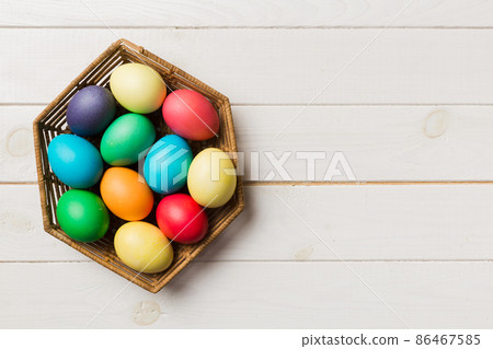 Multi colors Easter eggs in the woven basket on colored background . Pastel color Easter eggs. holiday concept with copy space Multi colors Easter eggs in the woven basket on colored background . Pastel color Easter eggs. holiday concept with copy space 86467585
