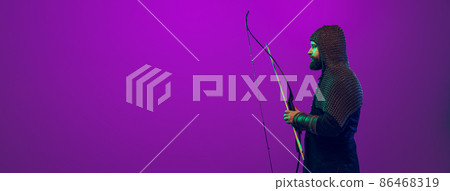 Flyer with young bearded man in image of medieval warrior, archery in chain armor isolated over purple background in neon. Comparison of eras 86468319
