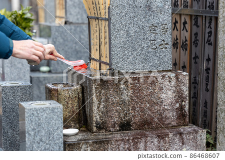 A man visiting a grave and cleaning the grave A man visiting a grave and cleaning the grave 86468607
