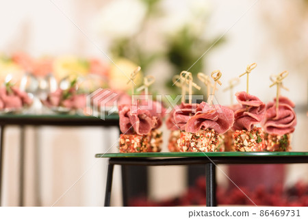 Set of beautiful canapes on skewers for buffet table. Cheese and ham on skewers. Close-up, selective focus. 86469731