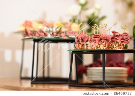 Set of beautiful canapes on skewers for buffet table. Cheese and ham on skewers. Close-up, selective focus. 86469732